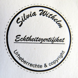 May include: A black and white circular stamp with the text "Silvia Wilhelm Echtheitszertifikat Urheberrechte & copyright" in a cursive font.