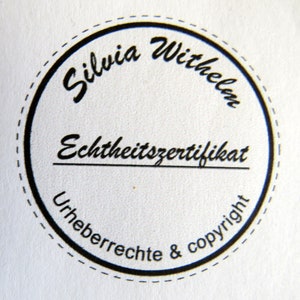 Op de afbeelding: Een zwarte en witte ronde stempel met de tekst "Silvia Wilhelm Echtheitszertifikat Urheberrechte & copyright" in een cursief schrift.