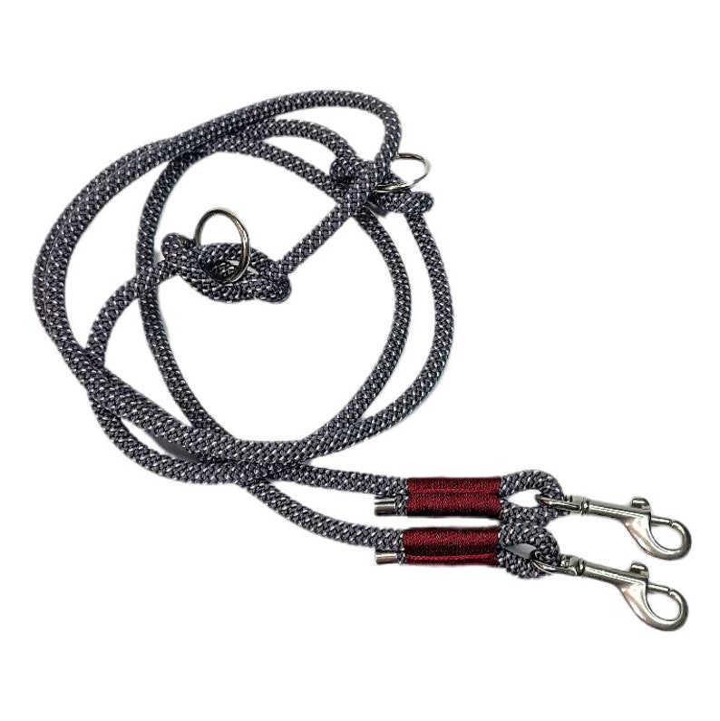 May include: A gray and black double dog leash with red accents and two silver clips.