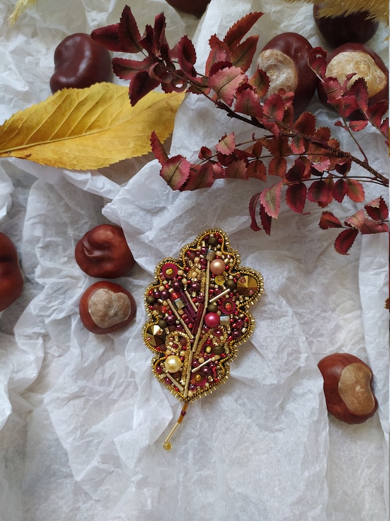 Gold and red beaded brooch oak leaf. Handwork.