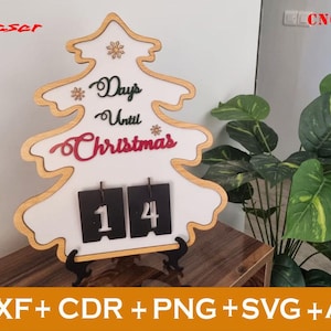 May include: A white wooden Christmas tree cutout with the text "Days Until Christmas" and a flip-style countdown clock showing "14".