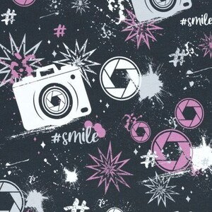 May include: A black and white seamless pattern featuring a camera, lens, stars, and the hashtag #smile. The pattern is repeated throughout the design.