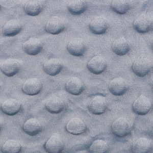 Könnte beinhalten: Nahaufnahme eines hellblauen Stoffes mit einem strukturierten Muster aus kleinen, erhabenen Kreisen.