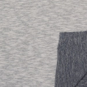 May include: A close-up of two fabric swatches. The top swatch is a light grey with a subtle heather pattern. The bottom swatch is a dark grey with a similar heather pattern.