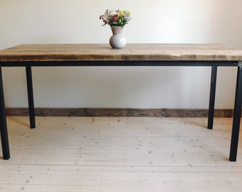 Dining table made of scaffolding planks with straight steel legs