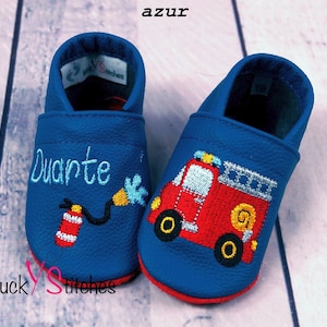Könnte beinhalten: Ein Paar blaue Lederschuhe für Babys mit gestickten Feuerwehrwagen-Designs. Ein Schuh trägt den Namen "Duarte".