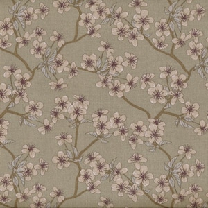 Op de afbeelding: Een beige stof met een herhalend patroon van witte bloemen met bruine centra. De bloemen zijn in clusters langs takken gerangschikt.