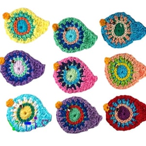 Könnte beinhalten: Neun farbenfrohe, gehäkelte Vogel-Applikationen. Jeder Vogel hat ein kreisförmiges Design mit verschiedenen Farben wie Gelb, Blau, Grün, Lila, Rosa und Rot. Sie haben kleine orangefarbene Schnäbel und schwarze Perlenaugen, ideal für Bastelprojekte.