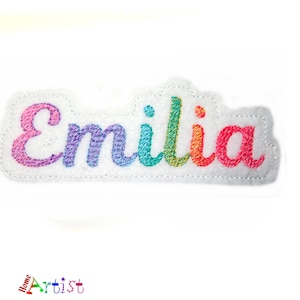 May include: Rainbow embroidered patch with the name "Emilia" in a white background.