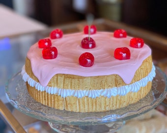 Nep Victoria-biscuitgebak, gegarneerd met roze glazuur en kersen, replica van voedselrekwisieten