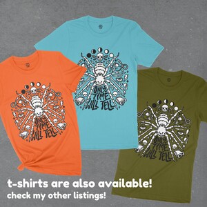 May include: Three t-shirts with a black and white graphic of a spider with the text "Only Time Will Tell" on a circle of moons, skulls, and eyes. The shirts are orange, turquoise, and olive green.