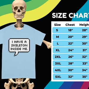 May include: A light blue t-shirt with a pixelated speech bubble that says "I have a skeleton inside me."  The size chart shows the chest and height measurements in inches for sizes S through 5XL.