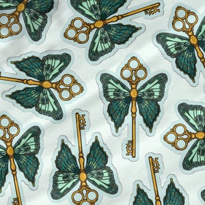 May include: A set of stickers featuring a whimsical design of a butterfly with a golden key. The butterfly has teal and green wings with intricate details. The key is ornate and has a circular design at the top.