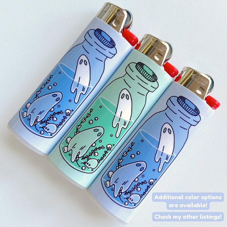 Puede incluir: Tres encendedores azules y verdes con un dise&ntilde;o de un fantasma en una botella. Los encendedores son blancos con un degradado azul, verde y azul claro. El texto en los encendedores dice "&iexcl;Opciones de color adicionales est&aacute;n disponibles! &iexcl;Mira mis otras listas!"