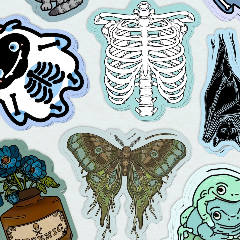 May include: A set of nine stickers featuring various designs, including a skeleton, a butterfly, a frog, a bat, and a ghost. The stickers are printed on a white background with a blue border.