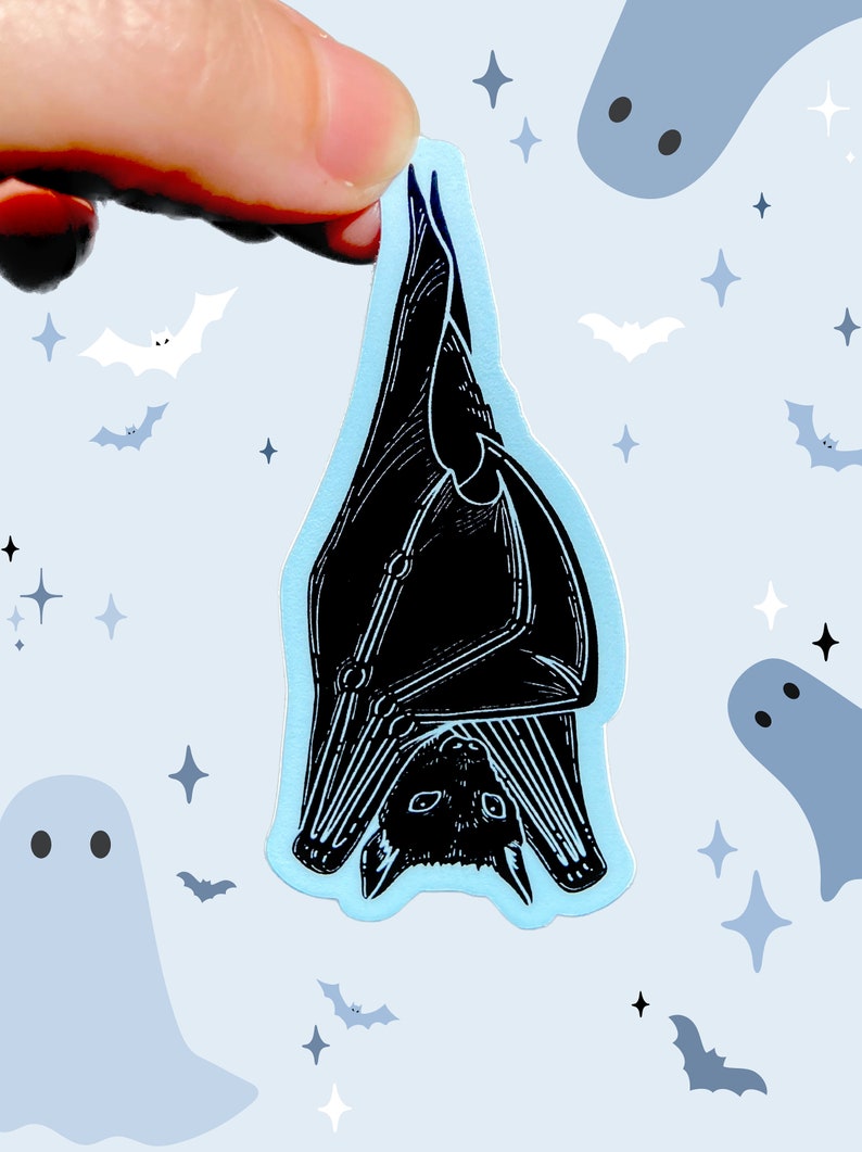 May include: A black bat sticker with a blue background. The bat is hanging upside down with its wings spread out. The sticker is surrounded by white stars and ghosts.