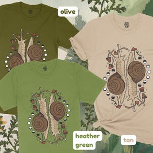 Pu&ograve; includere: Tre magliette con un design grafico di due lumache con funghi e fasi lunari. Le magliette sono di colore oliva, verde melange e marrone.