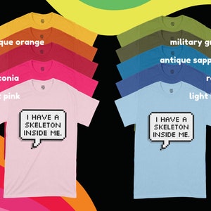 May include: A set of ten t-shirts in various colors, each featuring a pixelated speech bubble with the text "I HAVE A SKELETON INSIDE ME."
