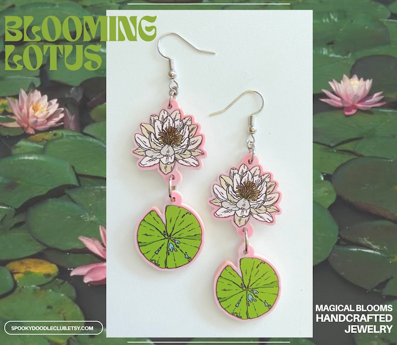 Op de afbeelding: Roze en witte lotusbloem oorbellen met groene waterlelies. De oorbellen zijn gemaakt van acryl en hebben een gedetailleerd bloemenontwerp. De tekst "BLOOMING LOTUS" staat in het groen bovenaan. De tekst "MAGICAL BLOOMS HANDCRAFTED JEWELRY" staat onderaan.