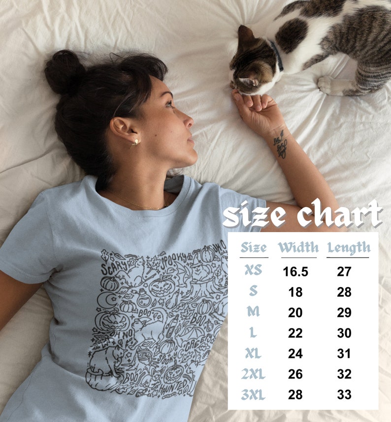 K&ouml;nnte beinhalten: Ein hellblaues T-Shirt mit einem schwarz-wei&szlig;en Grafikdruck von Halloween-Motiven. Das Shirt hat einen Rundhalsausschnitt und kurze &Auml;rmel. Die Gr&ouml;&szlig;entabelle zeigt die Breite und L&auml;nge des Shirts in Zoll f&uuml;r die Gr&ouml;&szlig;en XS bis 3XL.