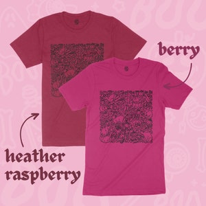 K&ouml;nnte beinhalten: Zwei T-Shirts mit einem Halloween-Motiv. Das T-Shirt links ist in der Farbe Heidelbeer-Melange und das T-Shirt rechts in der Farbe Beere.