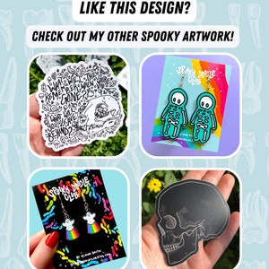 May include: Four different spooky themed enamel pins. The first pin is a black and white illustration of a skull with the text "What will they remember when you're gone? What will you leave behind?" The second pin is a pair of turquoise skeleton earrings with the text "Spooky Doodle Club". The third pin is a pair of ghost earrings with rainbow accents and the text "Spooky Doodle Club". The fourth pin is a black skull sticker.