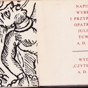 May include: An open book with a black and white illustration on the left page and text on the right. The illustration depicts a figure with a detailed, stylized design. The right page features Polish text in red, including the author's name and publication details.