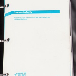 May include: A white document titled "Disk Operating System Version 3.3 Proof of License" with blue accents. The document is held together by a binder with metal rings. The IBM logo is visible at the bottom.