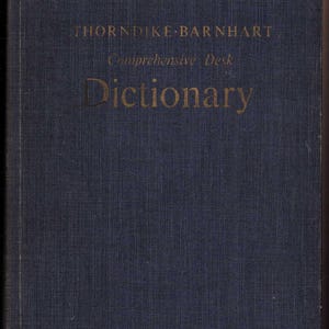以下が含まれることがあります： Thorndike-Barnhart Comprehensive Desk Dictionaryというタイトルの濃い青色のハードカバー本。表紙には布地の表面の中央に金色の文字が配置されており、タイトルが明確な大文字のフォントスタイルで表示されています。