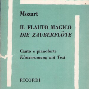 Puede incluir: Una partitura musical vintage con una cubierta turquesa y rayas blancas. La portada presenta el t&iacute;tulo "IL FLAUTO MAGICO DIE ZAUBERFL&Ouml;TE" de Mozart, con texto en italiano y alem&aacute;n. El nombre del editor, RICORDI, est&aacute; en la parte inferior.