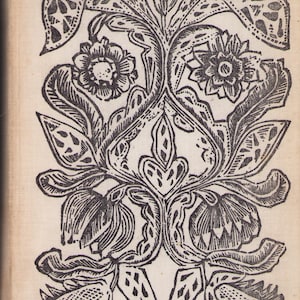 May include: Black and white floral woodcut print featuring stylized flowers, leaves, and decorative elements. The symmetrical design includes detailed linework, creating a vintage aesthetic. The print is on a cream-colored background.