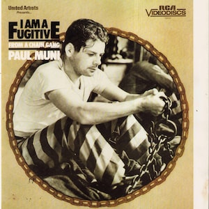 May include: A vintage RCA Videodiscs cover for the film I Am a Fugitive from a Chain Gang starring Paul Muni. The sepia-toned image features a person in striped pants holding a metal chain, framed by a circular chain-link border design.