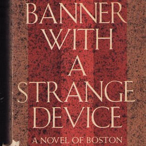 May include: A book cover featuring the title "A Banner With A Strange Device" in white capital letters. The background is a textured, reddish-brown with vertical stripes. The author's name, Arona McHugh, is at the bottom.