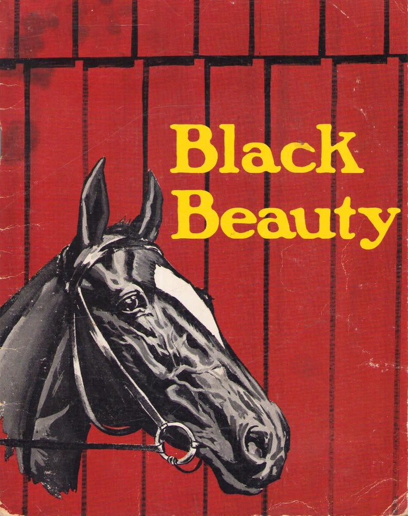 May include: A book cover featuring a black horse with a white blaze on its forehead, wearing a bridle. The background is a red barn wall with vertical black slats. The title Black Beauty is printed in large yellow letters on the right side.