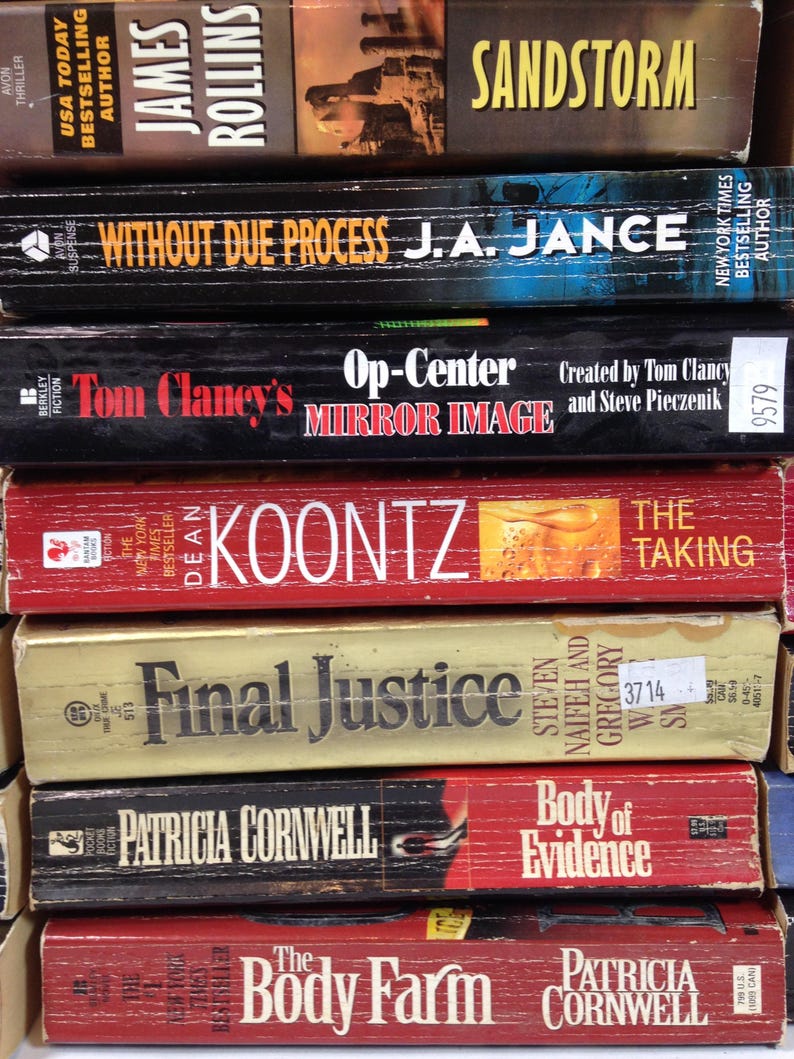 May include: A stack of paperback books with various titles and authors. Titles include "Sandstorm," "Without Due Process," "Op-Center Mirror Image," "The Taking," "Final Justice," "Body of Evidence," and "The Body Farm."