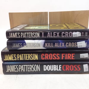 Puede incluir: Una pila de cuatro libros de tapa dura de James Patterson. Los títulos visibles son "I, Alex Cross", "Kill Alex Cross", "Cross Fire" y "Double Cross". Las lomos de los libros son negros con letras blancas y amarillas.