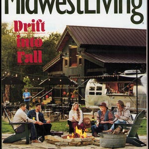 Könnte beinhalten: Die Herbstausgabe 2022 des Magazins Midwest Living zeigt auf dem Cover eine Gruppe von Menschen, die um eine steinerne Feuerstelle vor einer dunklen Scheune und einem silbernen Wohnwagen sitzen. Der Text lautet Drift into Fall und mehr.