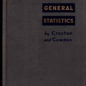May include: A vintage book titled "APPLIED GENERAL STATISTICS" by Croxton and Cowden. The book cover is a dark gray with the title in gold lettering within navy blue rectangles. The author's names are in a smaller, cursive font.