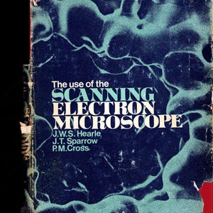 Peut inclure: Une couverture de livre vintage avec le titre "The use of the SCANNING ELECTRON MICROSCOPE" en blanc et turquoise. Le fond est bleu foncé avec un motif turquoise et les noms des auteurs.