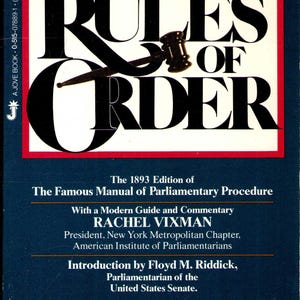 May include: A paperback book titled Robert's Rules of Order, The First and Only Edition in Paperback. The cover is dark blue with a white rectangle containing the title in large black letters and a black gavel graphic. It includes text by Rachel Vixman.