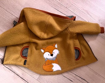 May include: A mustard yellow hooded jacket with a fox applique on the back. The jacket has two pockets with black and white striped fabric lining.
