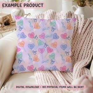 May include: Square pillow with a repeating pattern of heart-shaped lollipops in various colors, each with a different message. The background is a soft gradient of pink and purple. The text "EXAMPLE PRODUCT" is at the top.