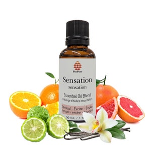 May include: A brown glass bottle with a white label that reads "Sensation sensation Essential Oil Blend mélange d'huiles essentielles Sensual - Excite - Evoke sensuel - exciter - évoquer 30 ml / 1 fl oz". The bottle is surrounded by citrus fruits, including oranges, limes, and grapefruits, as well as vanilla beans and a white orchid.