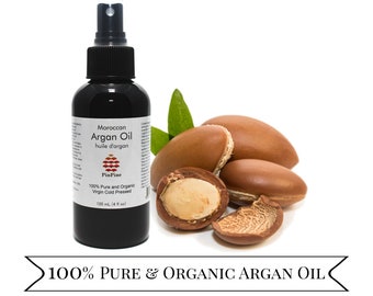 May include: A black spray bottle of Moroccan Argan Oil, with the text "100% Pure & Organic Argan Oil". The bottle is next to several brown argan nuts and green leaves. The bottle contains 120 mL (4 fl oz) of oil.