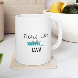 May include: White ceramic mug with a black and teal graphic that says "Please wait installing... JAVA" with a progress bar.
