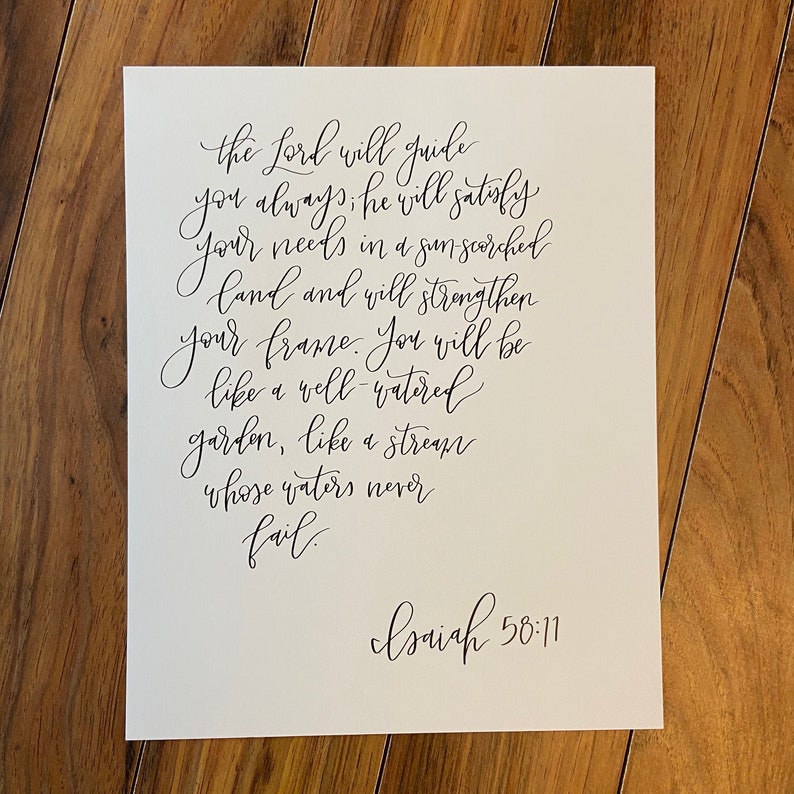 May include: A white background with black calligraphy that reads "the Lord will guide you always; he will satisfy your needs in a sun-scorched land and will strengthen your frame. You will be like a well-watered garden, like a stream whose waters never fail."  The text is followed by "Isaiah 58:11".