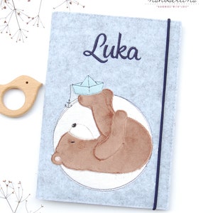 U-Hefthülle Teddy Luka mit Papierboot,  mit Fellimitat, Fach für Impfpass und Visitenkarte 3 in 1 * Filz *  individualisierbar