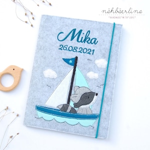 Untersuchungshefthülle / U-Heft-Hülle Waschbär Mika im türkisen Segelboot, Namen und Fach für Impfpass und Visitenkarte 3 in 1