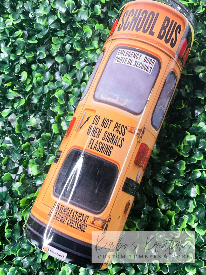 May include: A yellow school bus tumbler with the words "SCHOOL BUS" in black letters. The tumbler has a black stripe around the bottom and a black stripe around the top. The tumbler also has a black stripe around the middle with the words "EMERGENCY DOOR" and "PORTE DE SECOURS" in white letters. The tumbler also has a black stripe around the bottom with the words "THIS VEHICLE STOPS AT ALL RAILWAY CROSSINGS" in white letters. The tumbler also has a black stripe around the top with the words "DO NOT PASS WHEN SIGNALS FLASHING" in white letters.