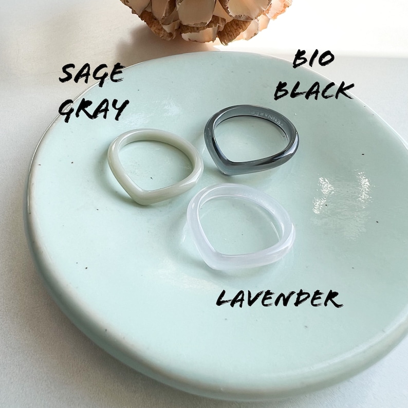 May include: Three resin rings in a light blue dish. The rings are in the colors sage gray, bio black, and lavender.